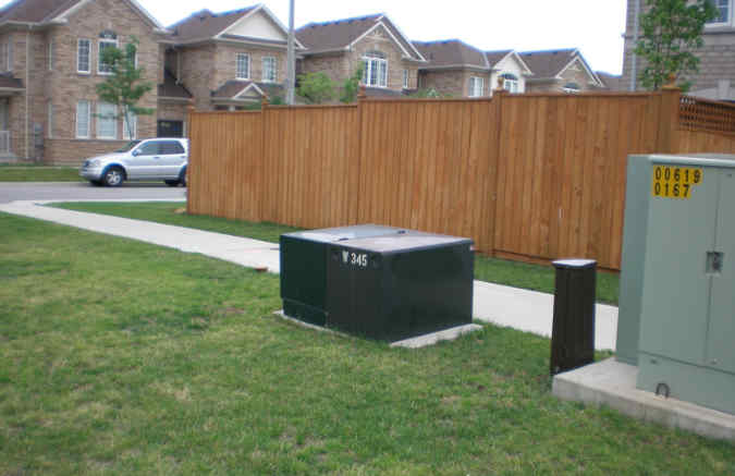 green transformer next to sidewalk