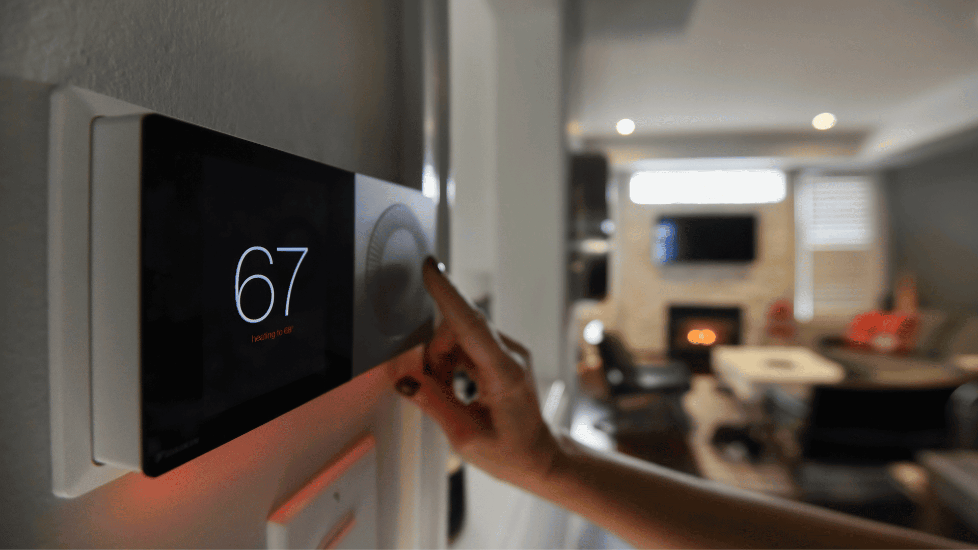 A person adjusts a digital thermostat set to 19 degrees in a modern lounge.